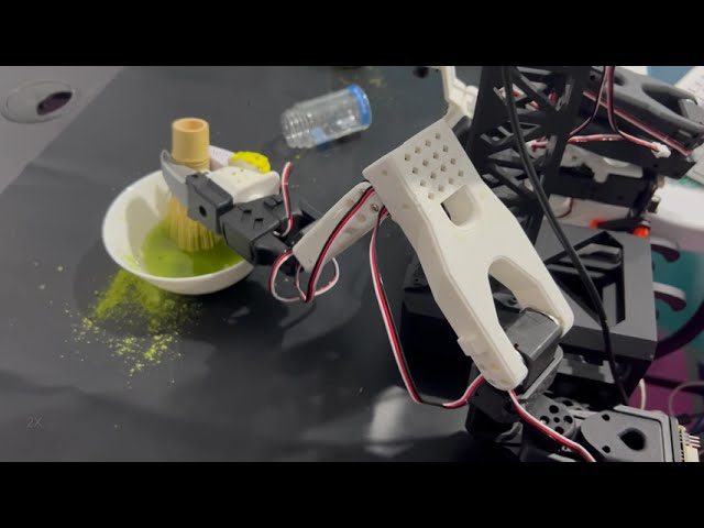 Matcha Bot's robot arm whisking matcha in a bowl, close up
