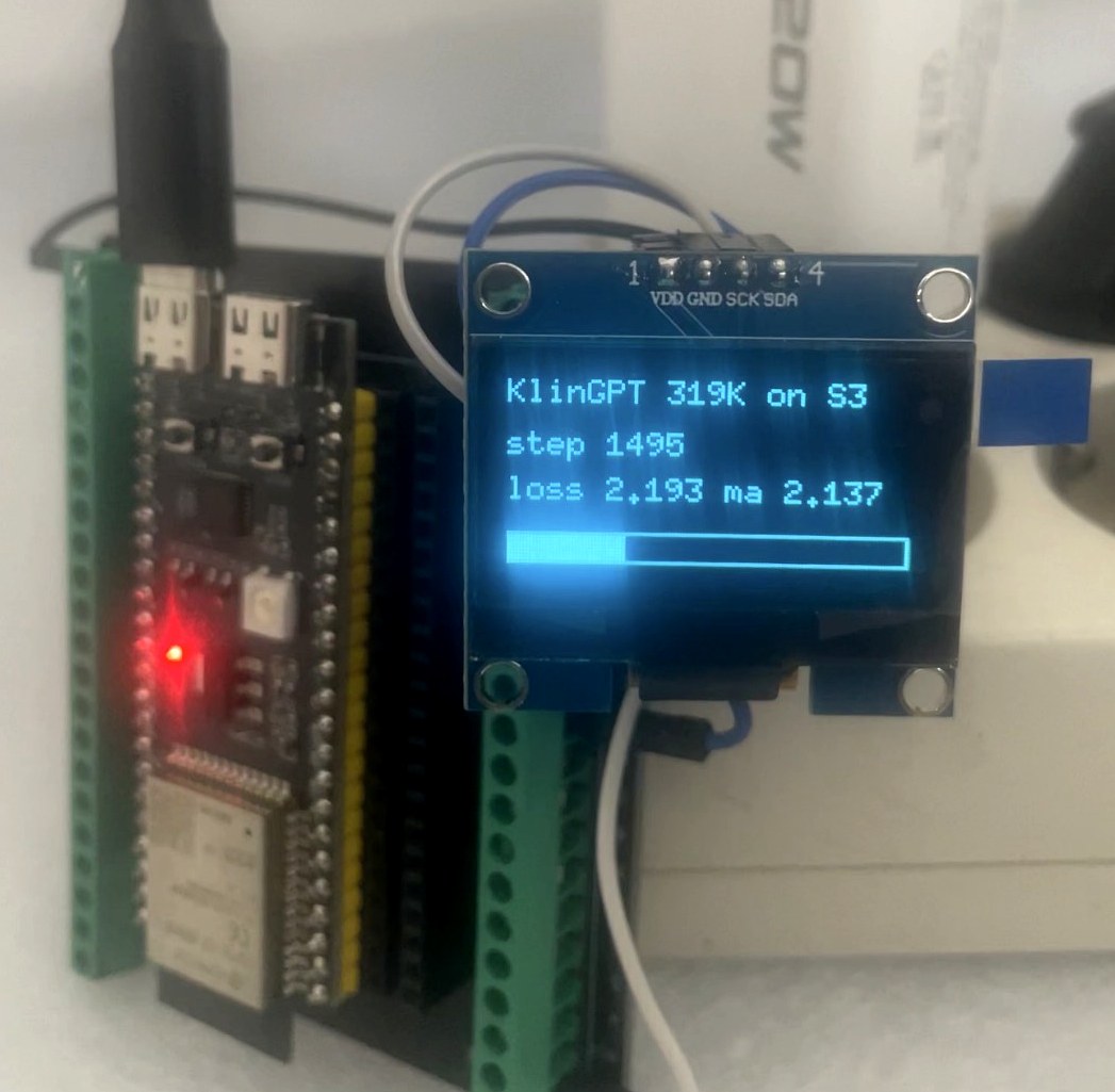 An ESP32-S3 dev board wired to a small blue OLED display reading 'KlinGPT 319K on S3, step 1495, loss 2.193 ma 2.137' with a partially-filled progress bar